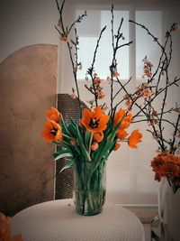 Close-up of orange flower vase on table at home