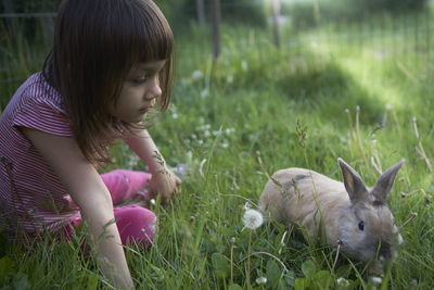 Girl with rabbit on grass