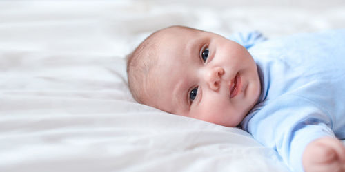 Close-up portrait of beautiful baby on white. newborn baby lying on its side. motherhood, health