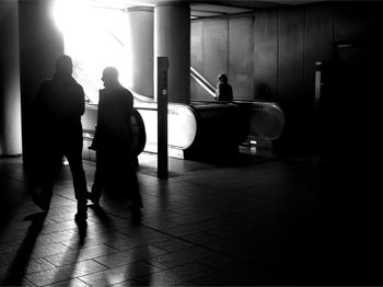 Rear view of silhouette people standing in corridor