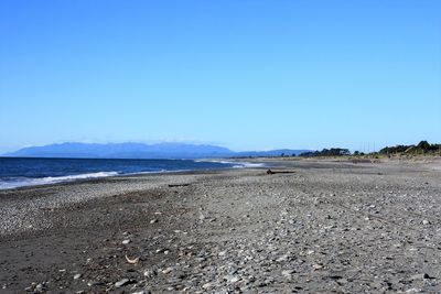 Scenic view of beach against clear blue sky