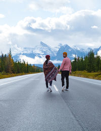 Rear view of man walking on road