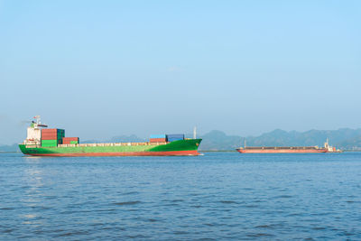 Ship sailing on sea against clear sky