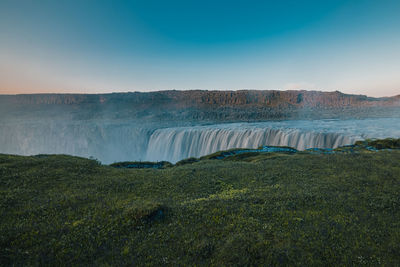 Scenic view of waterfall against sky