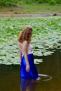 Rear view of woman standing in lake