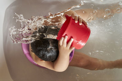 Kid washing her head in the shower.