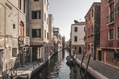 Canal amidst buildings in city against sky. venice, italy