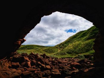 Scenic view of mountains seen through cave