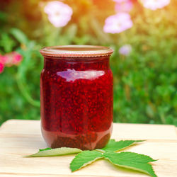 Banks with fragrant homemade raspberry jam in the garden. summer harvest.