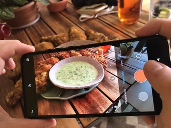 High angle view of person photographing food on table