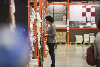 Side view of female customer shopping in hardware store