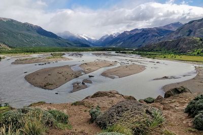 Scenic view of lake by mountains against sky