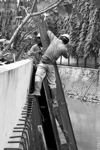 Man standing by boat against trees