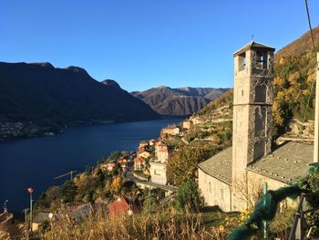 Scenic view of sea and buildings against clear blue sky