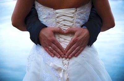 Midsection of woman holding umbrella standing against blurred background