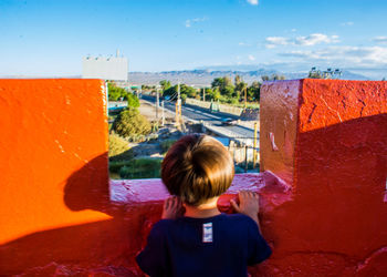 Rear view of a girl standing against sky