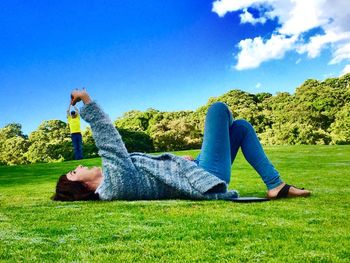 People relaxing on grassy field