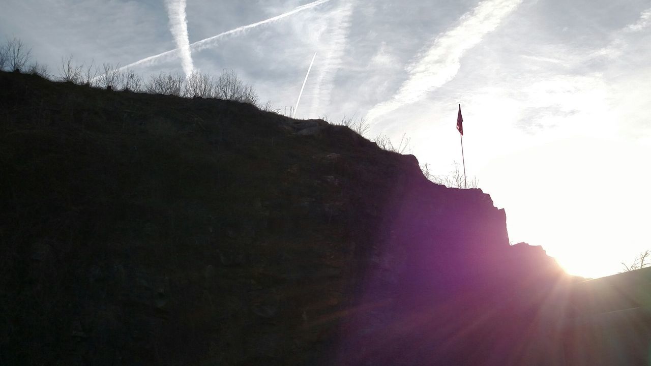 sun, sunbeam, sky, lens flare, sunlight, scenics, tranquility, mountain, low angle view, tranquil scene, beauty in nature, nature, cloud - sky, idyllic, outdoors, silhouette, sunny, bright, non-urban scene, rock - object