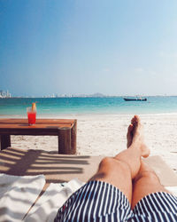 Low section of people relaxing on beach