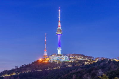 Low angle view of illuminated buildings against blue sky