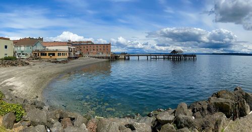 Panoramic view of sea and buildings against sky