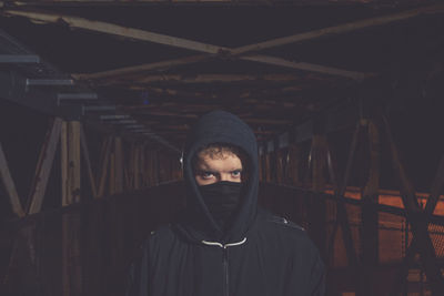 Portrait of young man standing on bridge at night