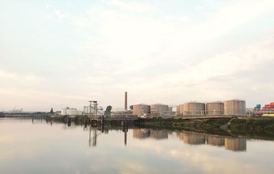 Reflection of city in water against sky