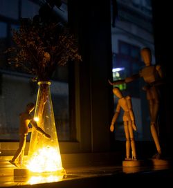 Illuminated light bulbs on table by trees at night
