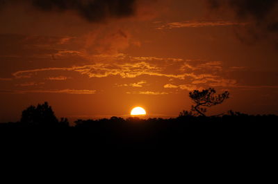 Silhouette landscape against sunset sky