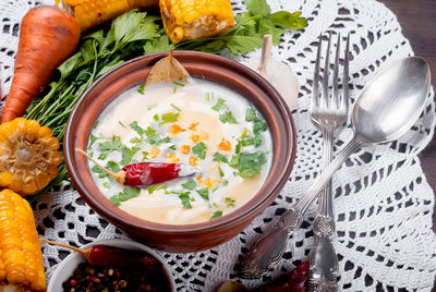 Close-up of soup served in bowl with vegetables on table