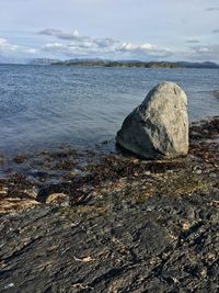 Scenic view of rocks on beach against sky