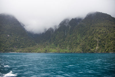 Scenic view of sea and mountains against sky