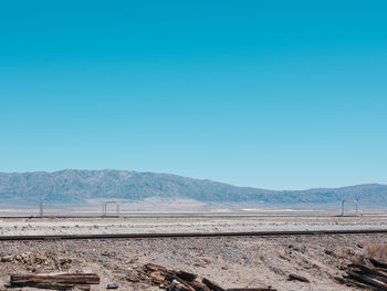 Scenic view of arid landscape against clear blue sky