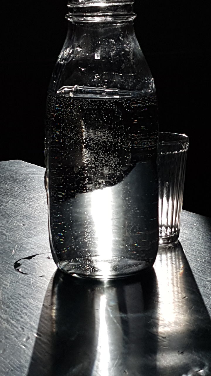 CLOSE-UP OF WATER BOTTLE ON TABLE