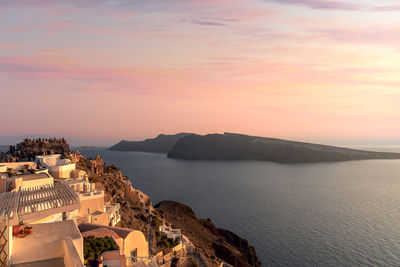 Panoramic view of sea and buildings against sky during sunset