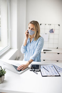 Full length of woman using laptop on table