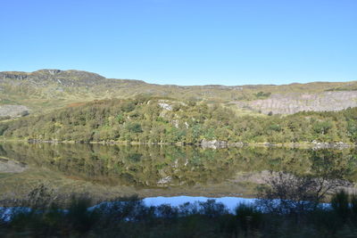 Scenic view of lake against clear blue sky