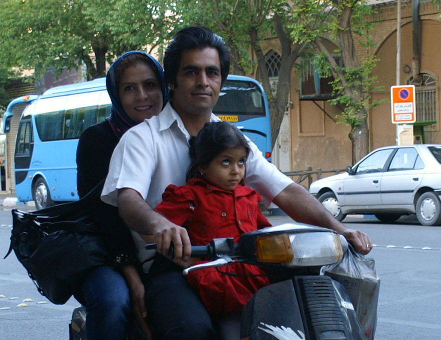 PORTRAIT OF FATHER WITH DAUGHTER SITTING ON CAR