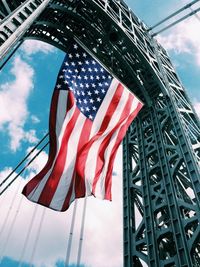 Low angle view of american flag below grid structure