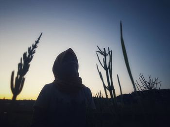 Rear view of silhouette man standing against sky during sunset