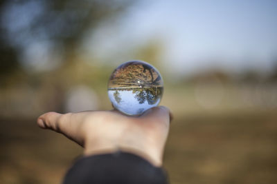 Close-up of hand holding lens ball