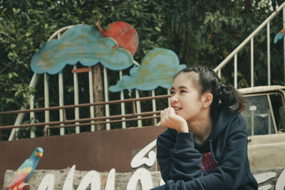 Smiling woman looking away while standing outdoors