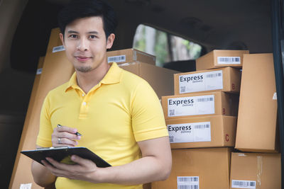 Portrait of young man holding camera in box