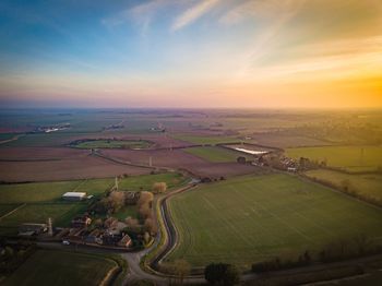 Aerial view of agricultural field against sky during sunset