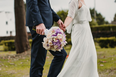 Rear view of friends holding bouquet of people