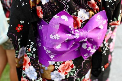 Close-up of woman with flowers against blurred background