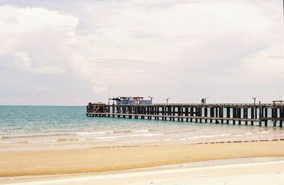 Pier on beach against sky