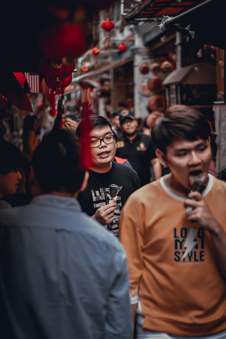 real people, men, lifestyles, group of people, people, casual clothing, standing, young men, leisure activity, waist up, young adult, togetherness, incidental people, front view, adult, crowd, happiness, selective focus, holding, women