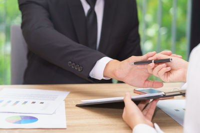 Midsection of couple holding hands on table