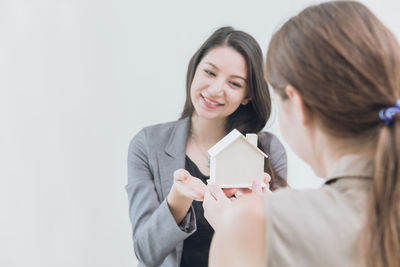 Portrait of a smiling young woman against white background